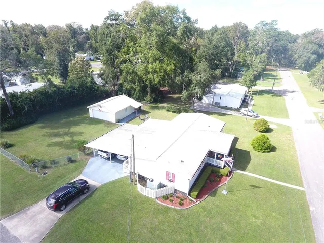 an aerial view of a house with swimming pool and a yard