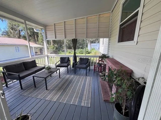 a view of a balcony with chairs and wooden floor