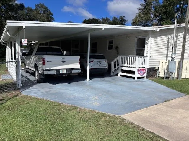 a view of a patio with table and chairs with wooden floor and fence