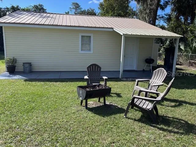 a view of a chair and table in backyard of the house