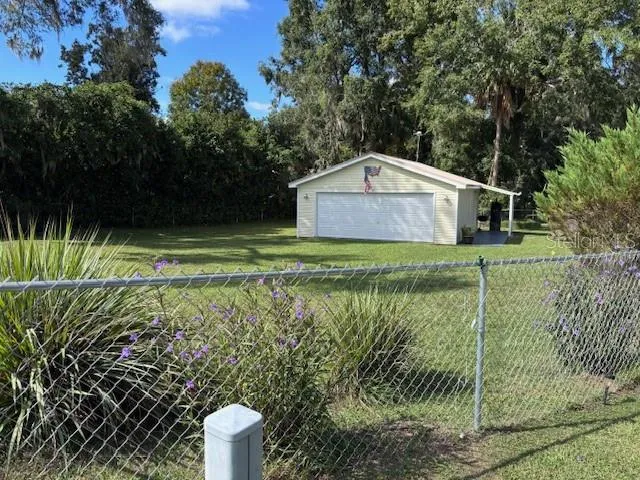 a view of a small house in a yard with large trees