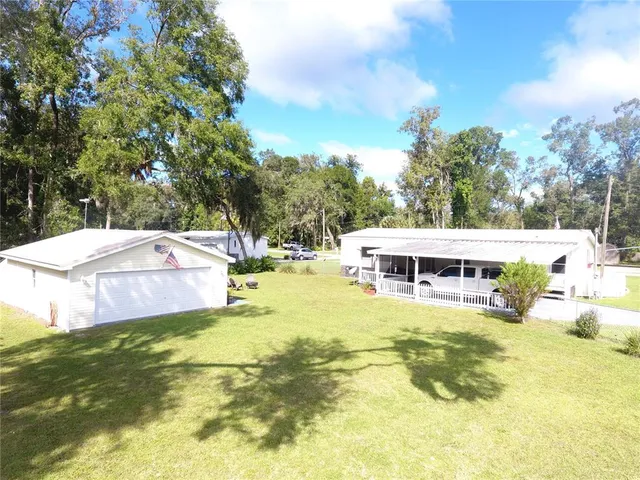 a view of a swimming pool with lawn chairs under an umbrella