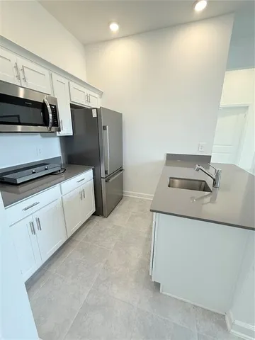 a kitchen with stainless steel appliances cabinets and wooden floor