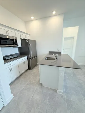 a kitchen with granite countertop a refrigerator and a stove top oven