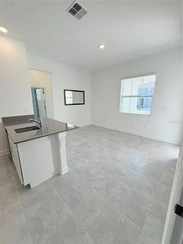 a view of a kitchen with furniture and wooden floor