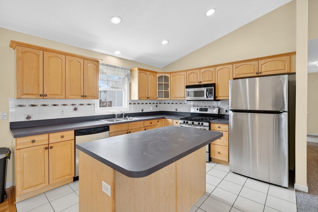 172 Stevens Street Fall River, MA 02721 - Photo 13 of 32 a kitchen with a refrigerator a microwave a sink and a counter top space