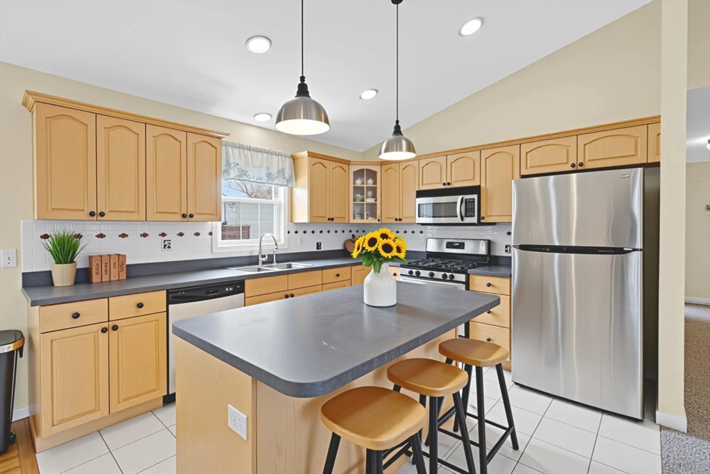 172 Stevens Street Fall River, MA 02721 - Photo 14 of 32 a kitchen with refrigerator cabinets dining table and chairs