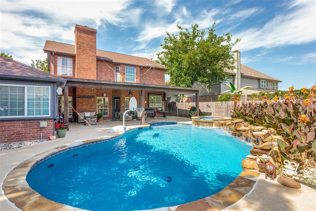 1228 Concho Drive Benbrook, TX 76126 - Photo 35 of 39 Backyard oasis featuring a freeform swimming pool with a rock waterfall and integrated spa