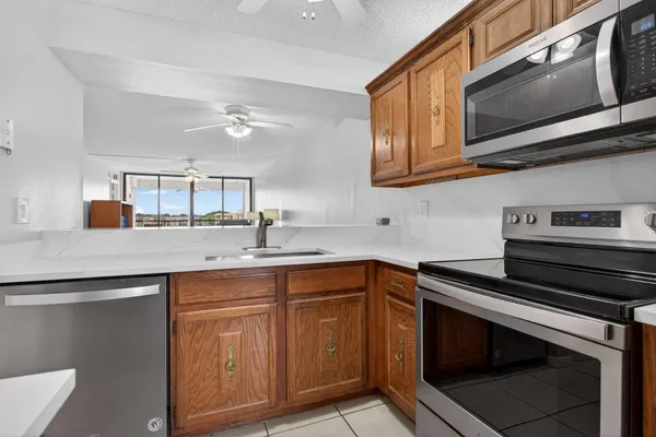 a kitchen with stainless steel appliances granite countertop a stove microwave and sink