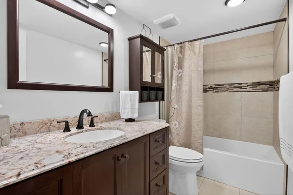 a bathroom with a granite countertop sink toilet and shower