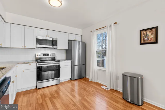 a kitchen with granite countertop a refrigerator stove and microwave