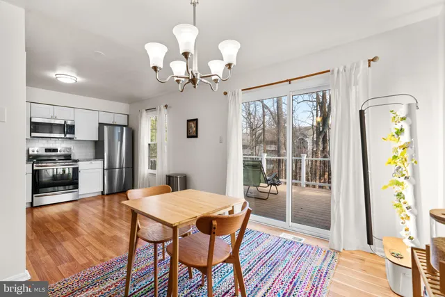 a view of a dining room with furniture a chandelier and wooden floor