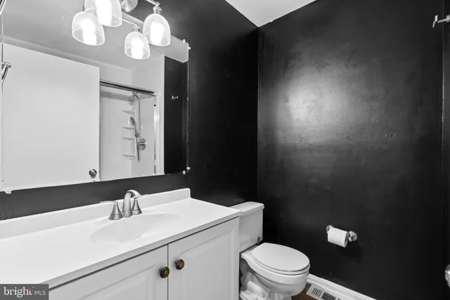a bathroom with a sink vanity mirror and toilet