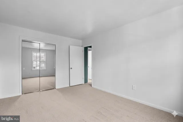 an empty room with sliding door and mirror