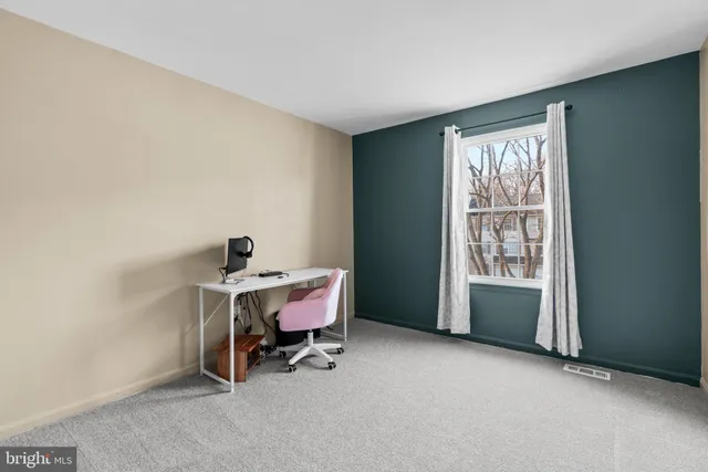 a view of a workspace with furniture and a window