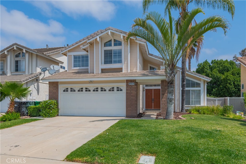 a front view of a house with a garden and plants