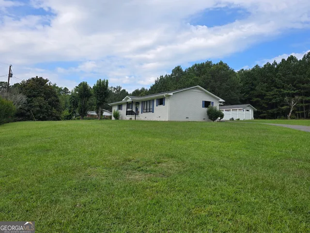 a view of a house with a yard and sitting area