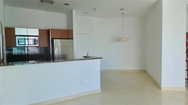 a view of kitchen with refrigerator and window