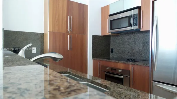 a kitchen with granite countertop a stove and a microwave