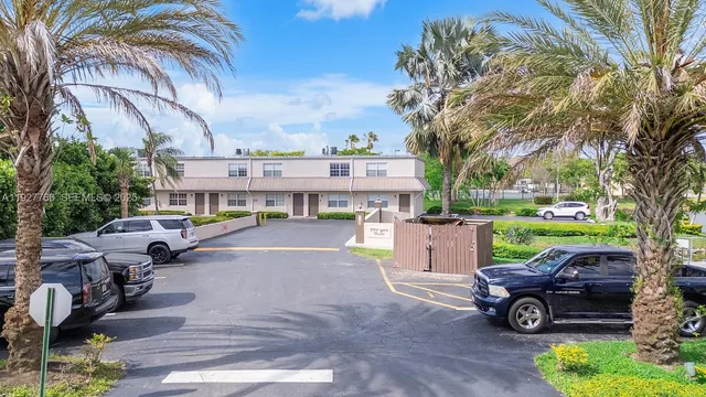 a view of a fountain with a bench in front of house