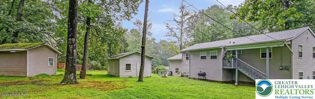 a backyard of a house with table and chairs