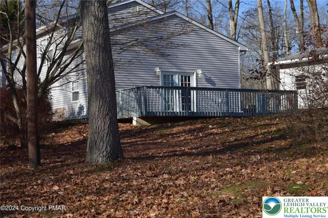 a view of a house with a yard and large tree