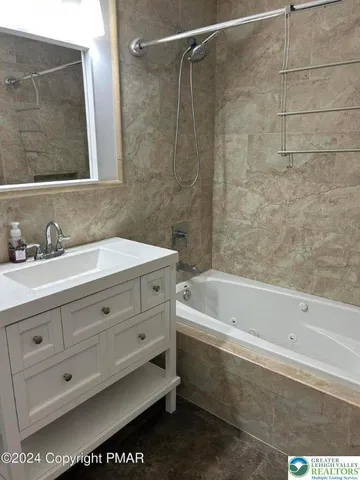 a bathroom with a bathtub a sink a vanity and a shower