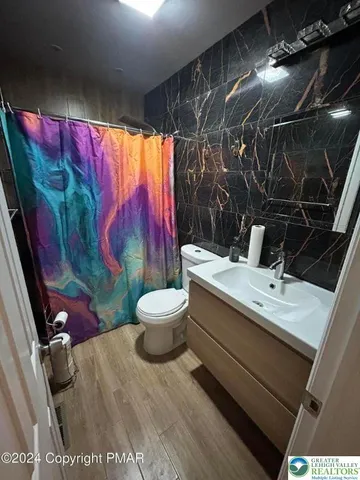 a bathroom with a sink mirror vanity and toilet