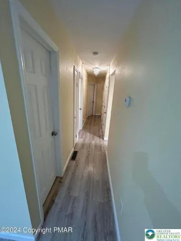 a view of a hallway with wooden floor
