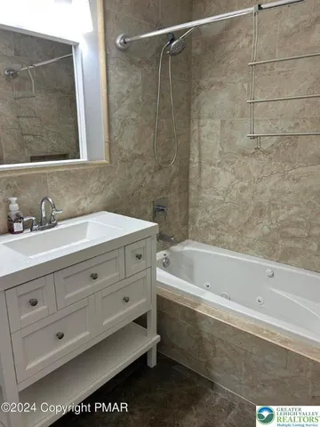 a bathroom with a bathtub a sink a vanity and a shower