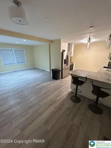 a view of a livingroom with wooden floor and a ceiling fan