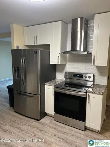 a kitchen with a stove refrigerator and microwave