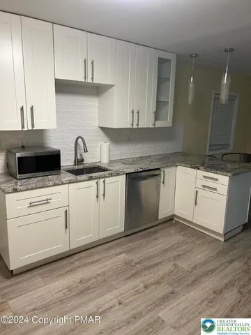 a kitchen with granite countertop a sink and cabinets