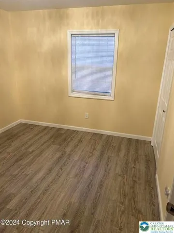 an empty room with wooden floor and closet