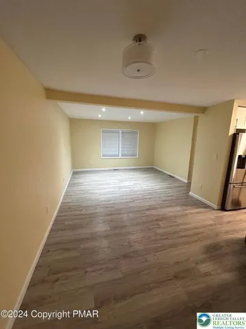 a view of an empty room and wooden floor