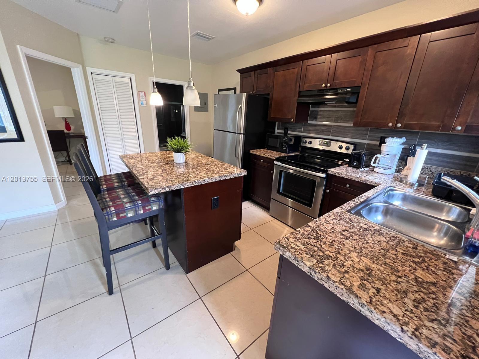 2015 Funston Street, Unit 2 Hollywood, FL 33020 - Photo 6 of 19 a kitchen with a stove a refrigerator and wooden cabinets