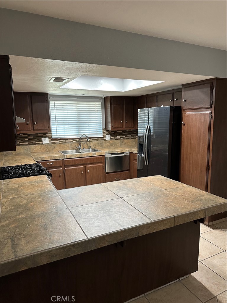 740 West Church Avenue Ridgecrest, CA 93555 - Photo 8 of 12 a kitchen with kitchen island a counter top space cabinets and stainless steel appliances