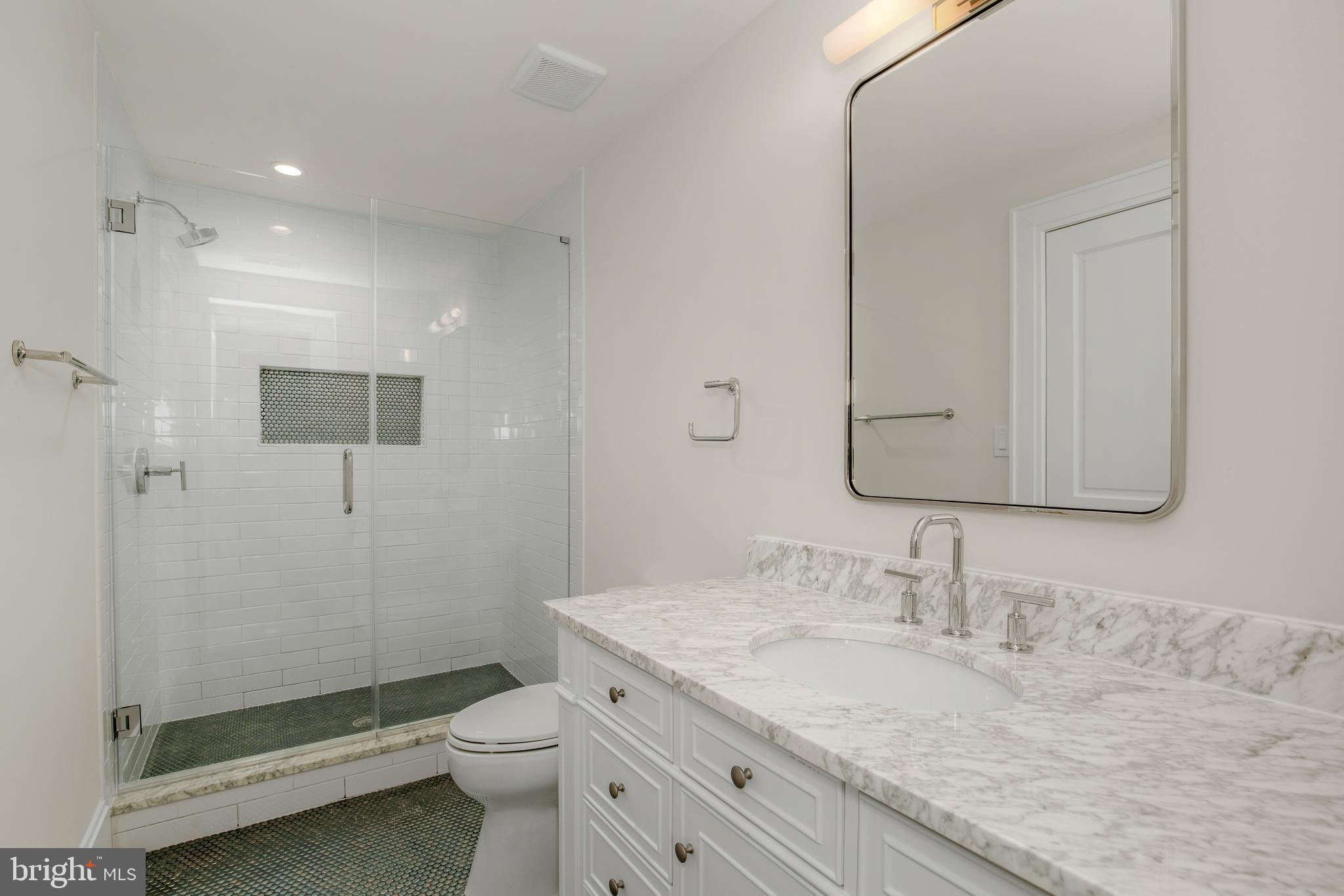 2710 36th Street Northwest Washington, DC 20007 - Photo 20 of 29 a bathroom with a granite countertop sink a toilet and shower