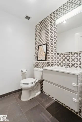 a bathroom with a toilet a sink and mirror