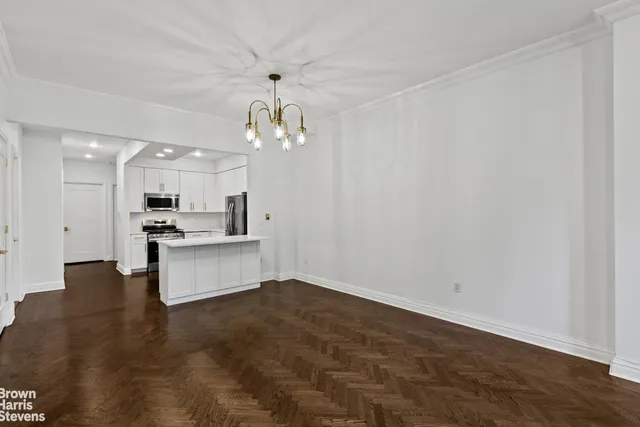 a view of kitchen with kitchen island white cabinets and refrigerator