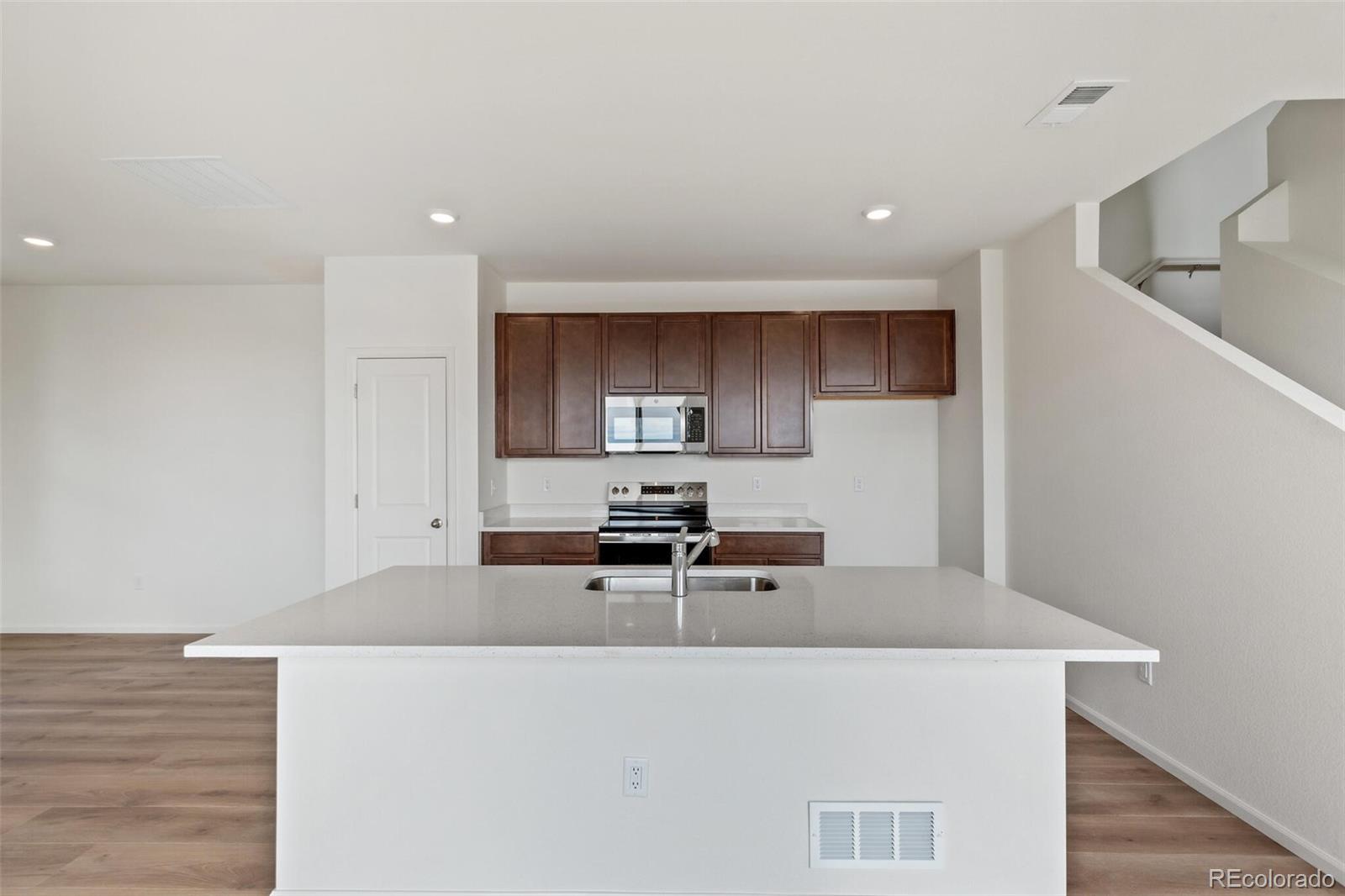 28636 East 6th Place Watkins, CO 80137 - Photo 12 of 32 a kitchen with stainless steel appliances granite countertop a sink a stove top oven a counter space and cabinets