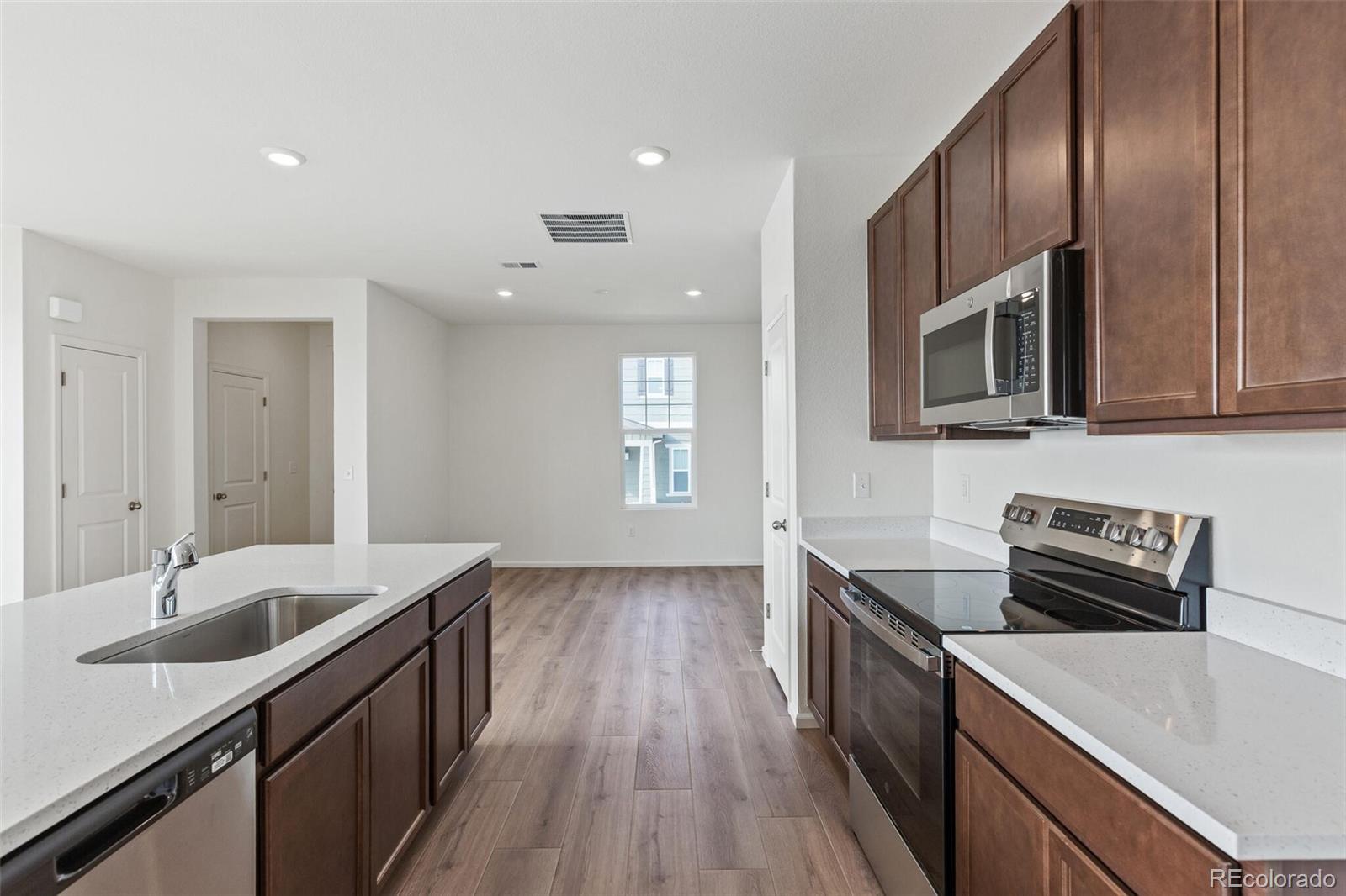 28636 East 6th Place Watkins, CO 80137 - Photo 14 of 32 a kitchen with a sink stove and microwave