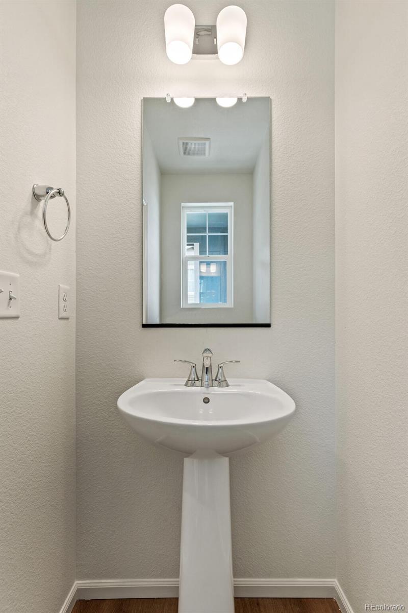 28636 East 6th Place Watkins, CO 80137 - Photo 16 of 32 a bathroom with a sink a mirror and a window