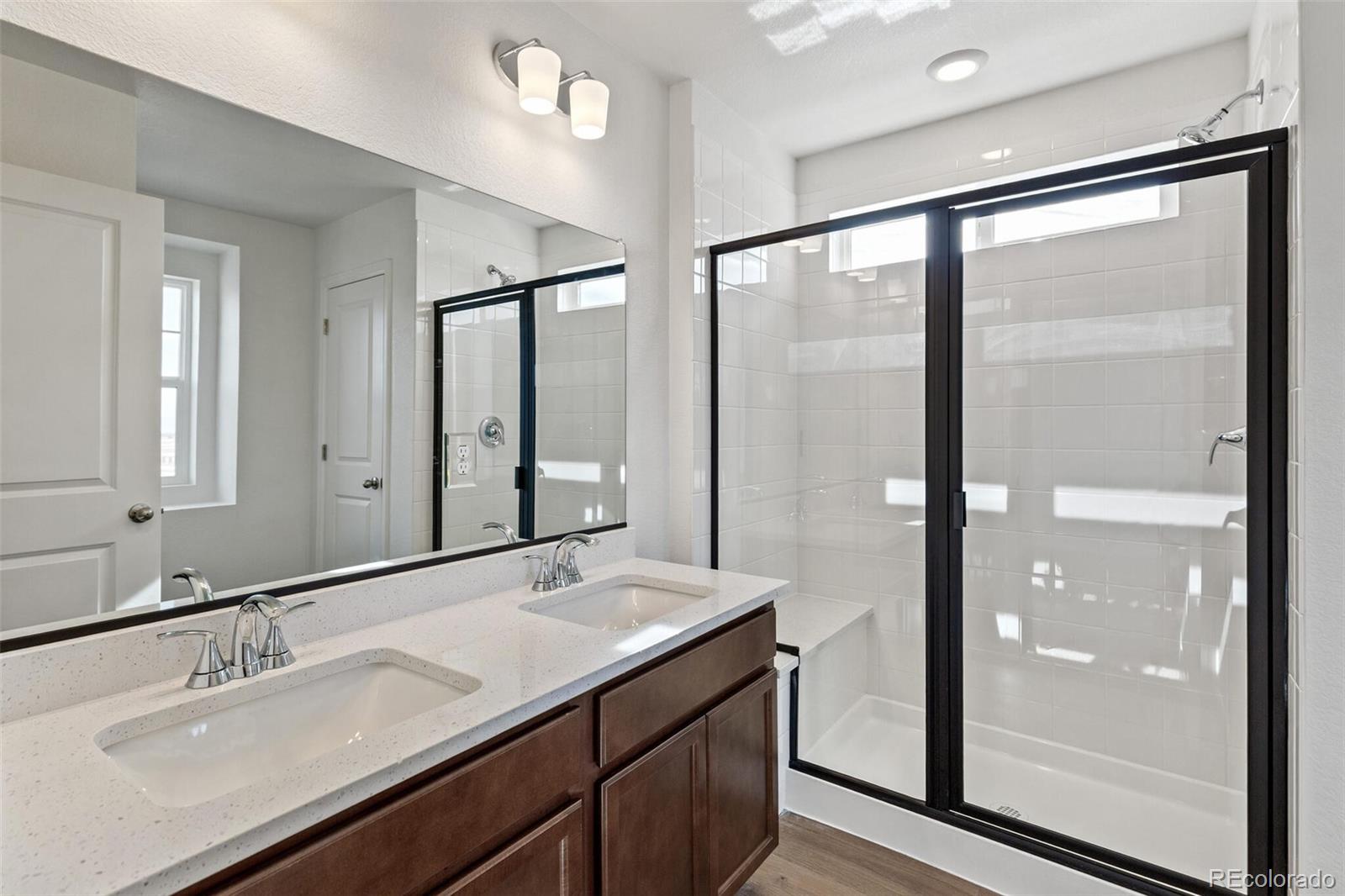 28636 East 6th Place Watkins, CO 80137 - Photo 21 of 32 a bathroom with a double vanity sink and mirror
