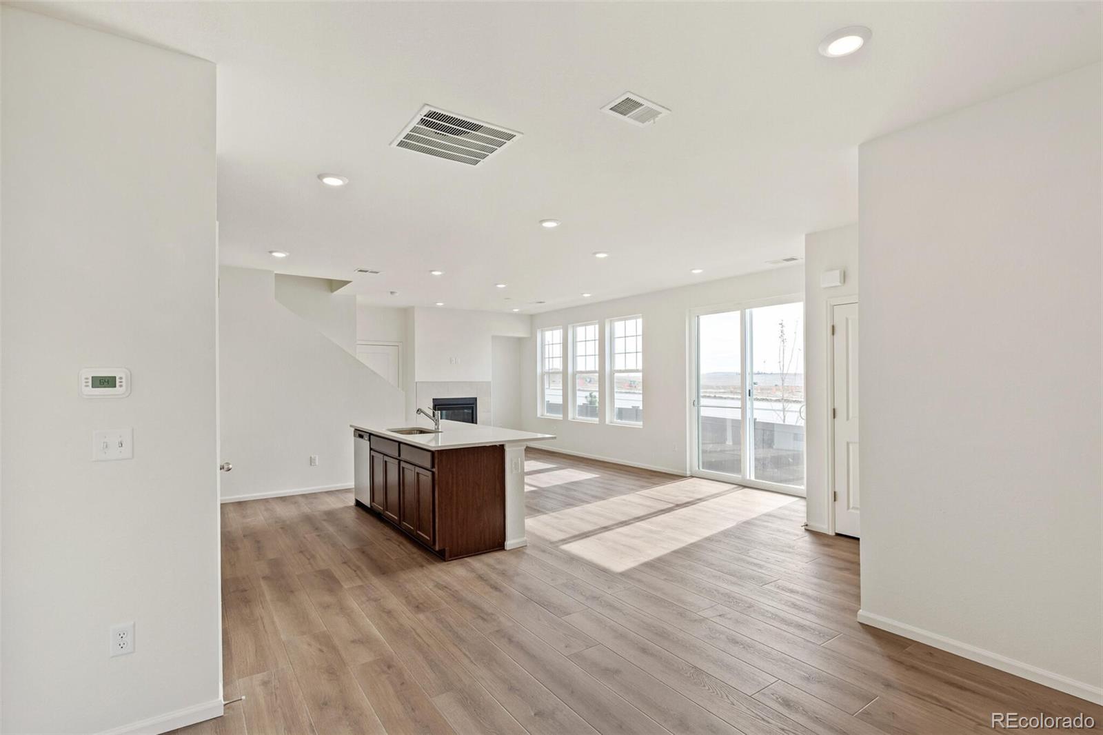 28636 East 6th Place Watkins, CO 80137 - Photo 6 of 32 a large hall with stainless steel appliances wooden floor and window