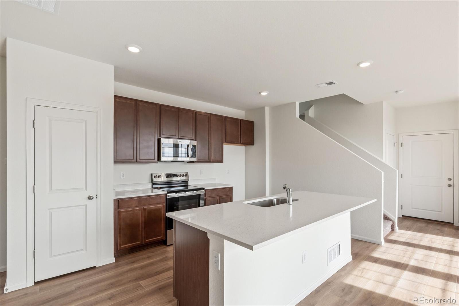 28636 East 6th Place Watkins, CO 80137 - Photo 10 of 32 a kitchen with stainless steel appliances a sink and a refrigerator