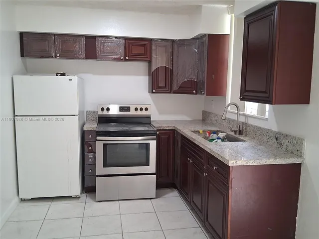 a kitchen with a stove top oven and sink