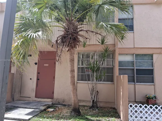 a front view of a house with a tree