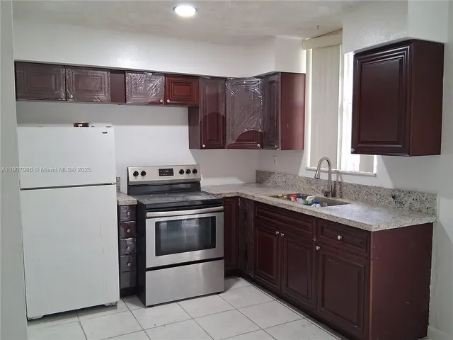 a kitchen with stainless steel appliances granite countertop a refrigerator stove a sink and dishwasher