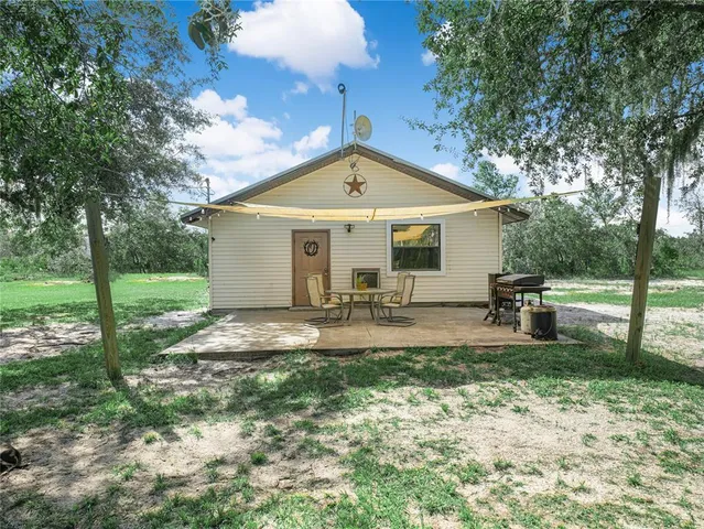 a view of a house with backyard and sitting area